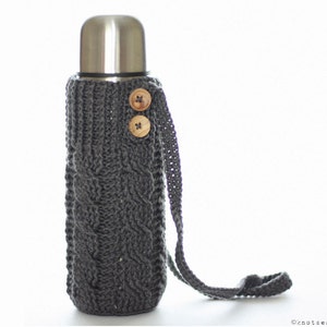 May include: Gray knitted thermal bottle cover with a long strap and two wooden buttons. The cover is designed to fit a standard-sized thermal bottle.