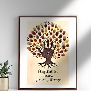 Puede incluir: Impresión artística enmarcada con un diseño de árbol hecho de huellas dactilares y una huella de mano. La obra de arte utiliza tonos marrones y dorados, con el texto "Planted in Jesus, growing strong."