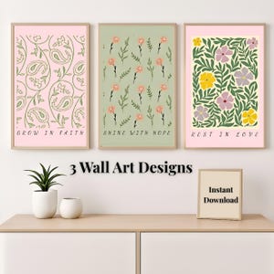 May include: Three framed wall art prints with floral designs and inspirational quotes. The prints feature a paisley pattern, floral sprigs, and a floral arrangement in pink, green, and cream colors. The text reads "GROW IN FAITH", "SHINE WITH HOPE", and "REST IN LOVE".