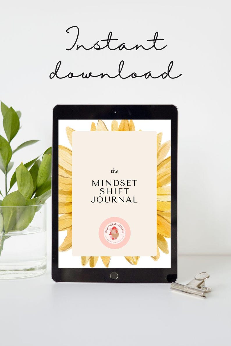 May include: A digital tablet displaying a digital download of "The Mindset Shift Journal" with a sunflower graphic and the text "Your Therapy Partner" in a pink circle.