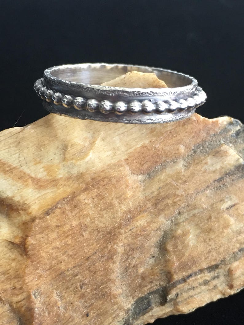 Pu&ograve; includere: Una tazza di ceramica bianca con manico nero e la scritta "But First, Coffee" in grassetto nero. La tazza &egrave; posta su uno sfondo neutro, evidenziando il suo design semplice.