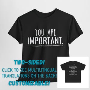 May include: Black t-shirt with the text "YOU ARE IMPORTANT." in white. The back of the shirt features the same text in multiple languages. The text on the back includes: "انت مهم", "TOONS IMPORTANTE", "អ្នកគឺជាមនុស្សសំខាន់", "NA BA", "OU INPOTAN", "MUNDARD TANAT".