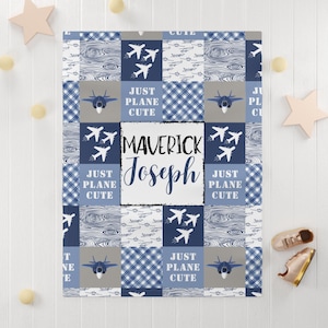 Puede incluir: Una manta para bebé azul y gris con un diseño de patchwork que presenta aviones, veta de madera y patrones de cuadros. La manta tiene el texto "Just Plane Cute" y el nombre "Maverick Joseph" impreso en ella.