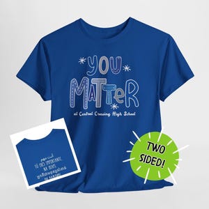 May include: A royal blue t-shirt with the words "YOU MATTER" in white and gray, with the text "at Central Crossing High School" below. A smaller image shows the same design in multiple languages. A green circle says "TWO SIDED!"