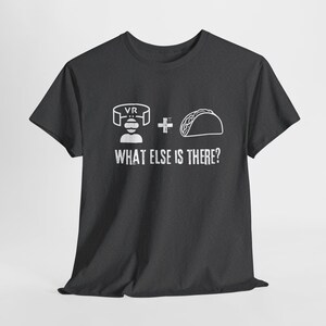 May include: A dark gray t-shirt with a white graphic of a person wearing a VR headset, a plus sign, and a taco. The text "WHAT ELSE IS THERE?" is printed below the graphic.