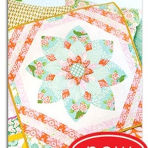 May include: A quilt pattern called "Prize Bloom" by Heather Bailey Sewing Patterns. The pattern features a large flower design in shades of pink, orange, green, and blue.
