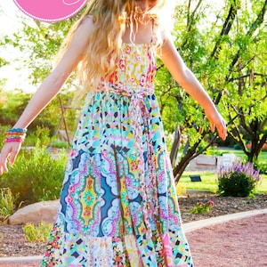 K&ouml;nnte beinhalten: Ein M&auml;dchen tr&auml;gt ein farbenfrohes Maxikleid mit Patchwork-Muster. Das Kleid hat eine Bindetaille und einen R&uuml;schen-Saum. Das Kleid hei&szlig;t "Bloomshine Maxi" und ist f&uuml;r Teenager und junge M&auml;dchen. Das Kleid ist Muster Nummer 37.