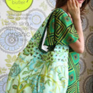 May include: A large, green and blue floral print tote bag with a black handle. The bag is made of organic cotton and is designed by Amy Butler.
