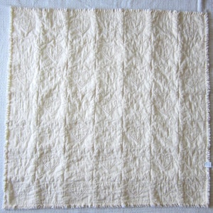 May include: A white quilted blanket with a subtle heart pattern stitched into the fabric.