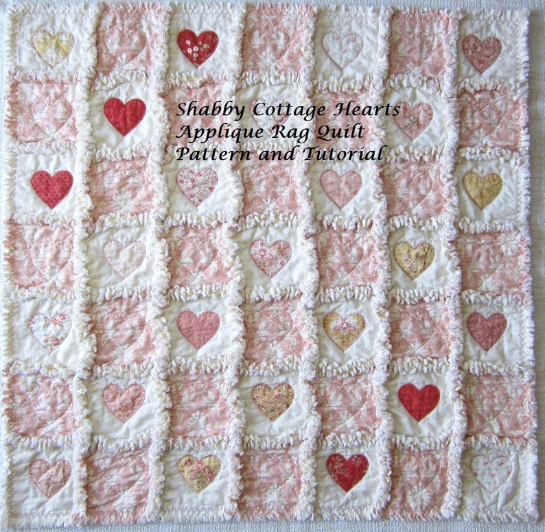 May include: A pink and white rag quilt with a patchwork design featuring appliqued hearts. The quilt has a shabby chic style and is made with a variety of fabrics. The text "Shabby Cottage Hearts Applique Rag Quilt Pattern and Tutorial" is printed on the quilt.