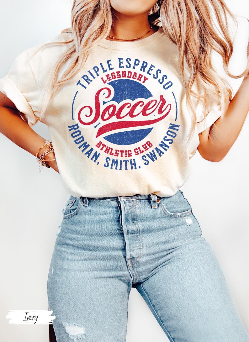 Puede incluir: Una camiseta blanca con un dise&ntilde;o gr&aacute;fico de estilo vintage con las palabras "Triple Espresso Legendary Soccer Rodman, Smith, Swanson Athletic Club".