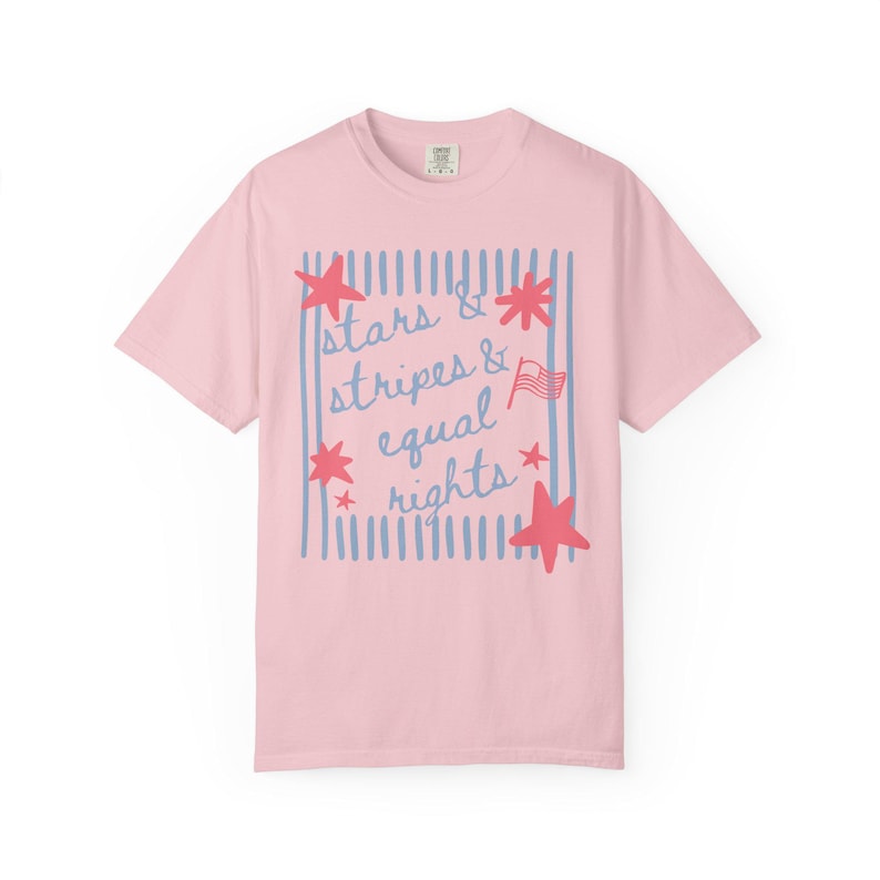 Puede incluir: Camiseta rosa claro con el texto "stars & stripes & equal rights" en azul y rojo. El dise&ntilde;o incluye estrellas rojas, rayas azules y una peque&ntilde;a bandera americana.