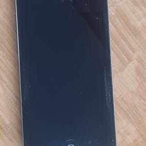 May include: A black rectangular media player with a silver border. The device has a black screen with a single button at the bottom. A small camera lens is visible at the top of the screen.