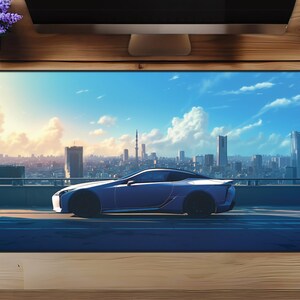 Può includere: Un'auto blu che guida su una strada di città con uno skyline sullo sfondo. Il cielo è blu con nuvole bianche.