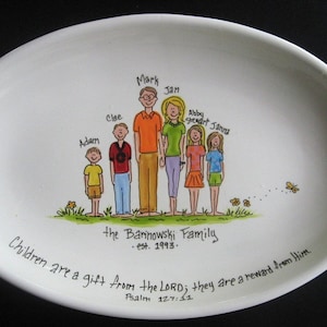 May include: A white oval ceramic platter with a hand-painted illustration of a family of seven. The family is standing in a line, with the parents in the center and their five children on either side. The parents are holding hands, and the children are smiling. The platter has the text "The Barinowski Family est. 1993." and a Bible verse about children being a gift from the Lord.