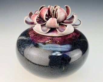 Ceramic cremation urn in black and purple with lotus flower lid