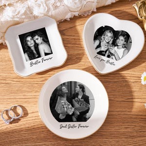 May include: Three white ceramic trinket dishes with gold rims, each featuring a black and white photo. One is square with "Bestie Forever", another heart-shaped with "Love you Bestie", and a round one with "Soul Sister Forever".
