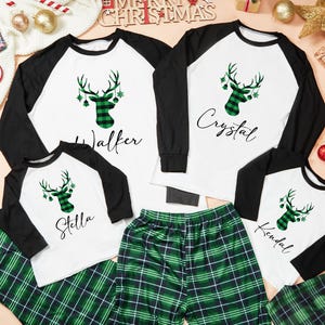 May include: Matching family Christmas pajamas. White tops with black sleeves and a green plaid deer head design. The names Walker, Crystal, Stella, and Kendal are printed on the shirts. Green plaid pajama pants complete the set.