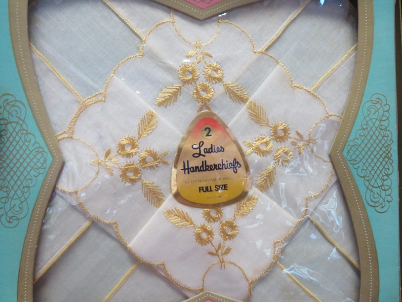 May include: Two white handkerchiefs with gold floral embroidery, packaged in a decorative box. The handkerchiefs have scalloped edges and are labeled "Ladies Handkerchiefs, Full Size."