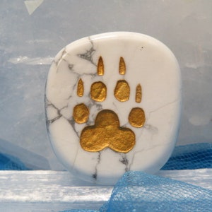 May include: White howlite stone with a gold bear paw print design.