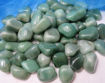 May include: A collection of smooth, green tumbled stones. The stones are various sizes and shapes, and have a polished, glossy finish.