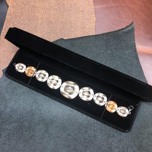 Bracelet made from US Coins (Half Dollar, Quarters, Nickels, Pennies, and Dimes) formed Cowboy Hats with lobster clasp closure.