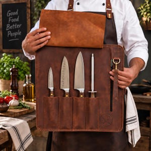 Könnte beinhalten: Eine braune Messertasche aus Leder mit vier vertikalen Fächern, die drei Küchenmesser aus Edelstahl und einen Wetzstahl enthalten. Die Tasche verfügt über eine Klappe, einen messingfarbenen Metallverschluss und ein rundes Logo unten rechts.