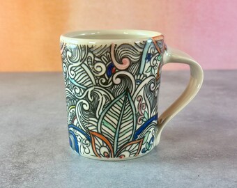 Colorful handmade pottery mug // white porcelain mug with floral and leaf patterns, coffee lover's gift,  orange, blue and pink patterned