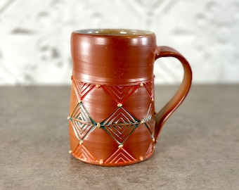 Soda-fired mug with geometric pattern // Handmade stoneware pottery mug with shino pattern with inlaid red, orange and turquoise. 12 oz mug.