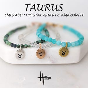 May include: Three beaded bracelets with Taurus zodiac charms. The bracelets feature emerald, crystal quartz, and amazonite beads. Each bracelet has a different coloured charm: silver, rose gold, and gold.