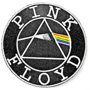 May include: A circular embroidered patch featuring a black background with a white border. The design displays a white triangle prism with a beam of white light entering and exiting as a rainbow spectrum. The text PINK FLOYD is in white.