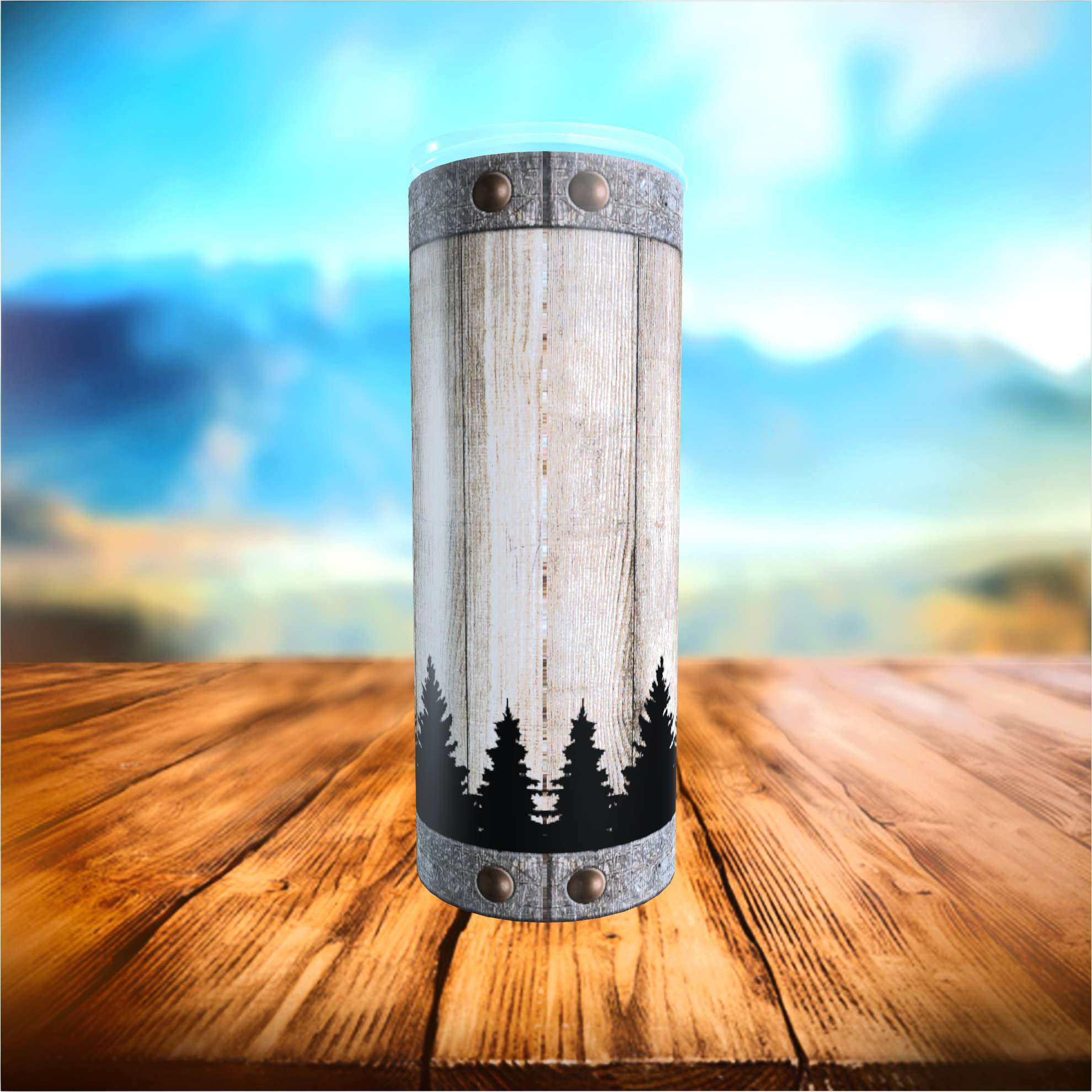 May include: A tall, cylindrical tumbler with a rustic design. The tumbler has a wood-grain pattern with a black silhouette of pine trees at the base. Metal bands with rivets encircle the top and bottom, and a clear lid is visible.