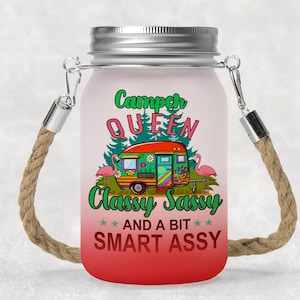 May include: A mason jar with a rope handle and a pink, green and white design. The jar has the text "Camper Queen Classy Sassy And A Bit Smart Assy" on it.