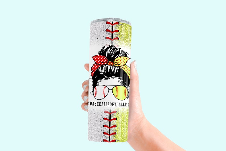 May include: A white tumbler with a glitter finish and a baseball and softball design. The tumbler features a woman with a bun and a red and yellow polka dot headband. The text "#BASEBALLSOFTBALLMOM" is printed on the tumbler.