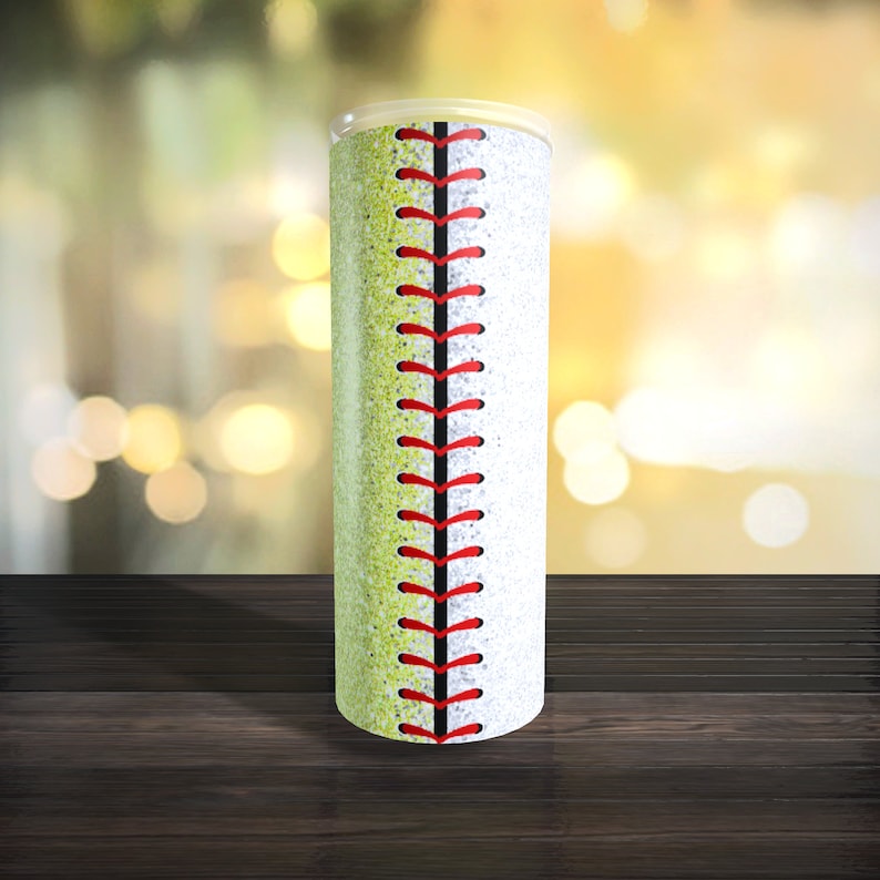May include: A white and yellow tumbler with a red baseball stitch design. The tumbler is made of stainless steel and has a glitter finish.