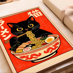 Puede incluir: Impresi&oacute;n enmarcada de un gato negro comiendo ramen. El gato tiene ojos amarillos y usa palillos. El cuenco de ramen est&aacute; decorado con un dise&ntilde;o de drag&oacute;n rojo. El fondo es rojo con texto japon&eacute;s. La impresi&oacute;n est&aacute; en un marco de madera.