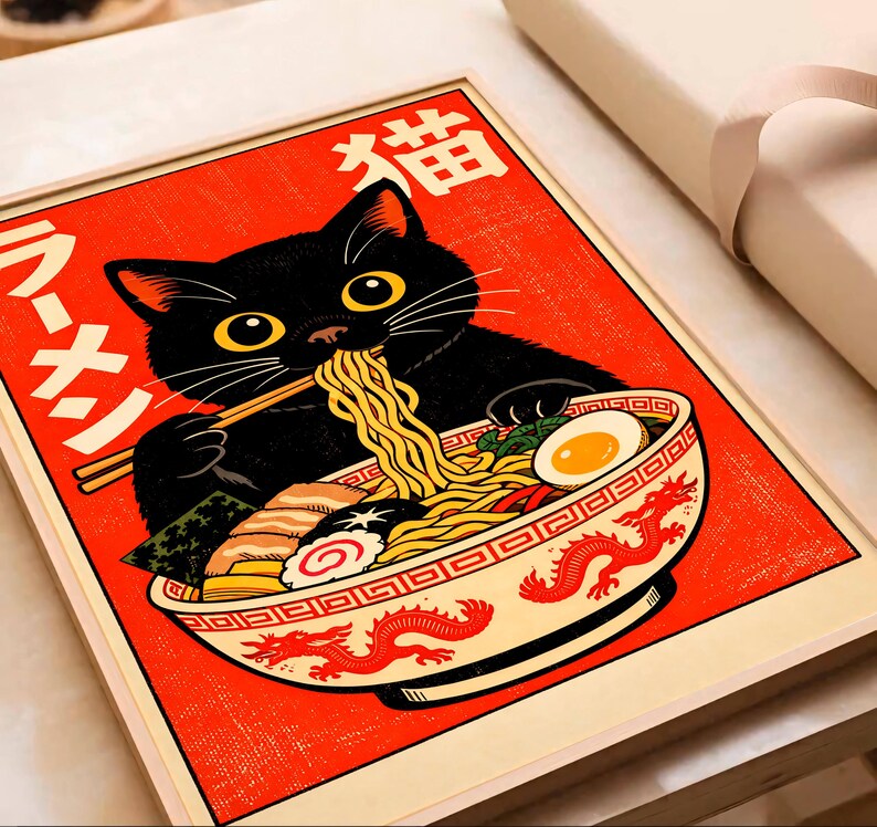 Puede incluir: Impresi&oacute;n enmarcada de un gato negro comiendo ramen. El gato tiene ojos amarillos y usa palillos. El cuenco de ramen est&aacute; decorado con un dise&ntilde;o de drag&oacute;n rojo. El fondo es rojo con texto japon&eacute;s. La impresi&oacute;n est&aacute; en un marco de madera.