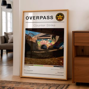 May include: A framed poster featuring the game "Overpass" from Counter-Strike. The image shows a graffiti-covered tunnel under a bridge. The poster includes text such as "Scenario: Bomb Defusal" and "Developer: Valve Corporation."