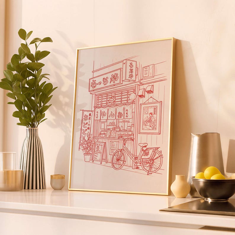 May include: A framed print featuring a red line drawing of a Japanese restaurant with a bicycle parked outside. The artwork includes Japanese text and a detailed depiction of the shop's facade, with hanging lanterns and signage.