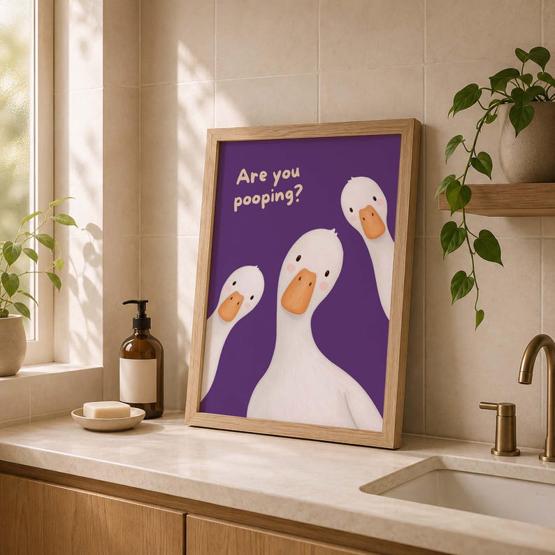 May include: A framed wall art print featuring a purple background with three white cartoon ducks with orange beaks. The text "Are you pooping?" is printed in a light cream color in the upper left corner of the illustration.