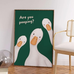 May include: A rectangular wall art print featuring three white geese with orange beaks on a dark green background. The text "Are you pooping?" is printed in a light cream color in the upper left corner of the framed artwork.
