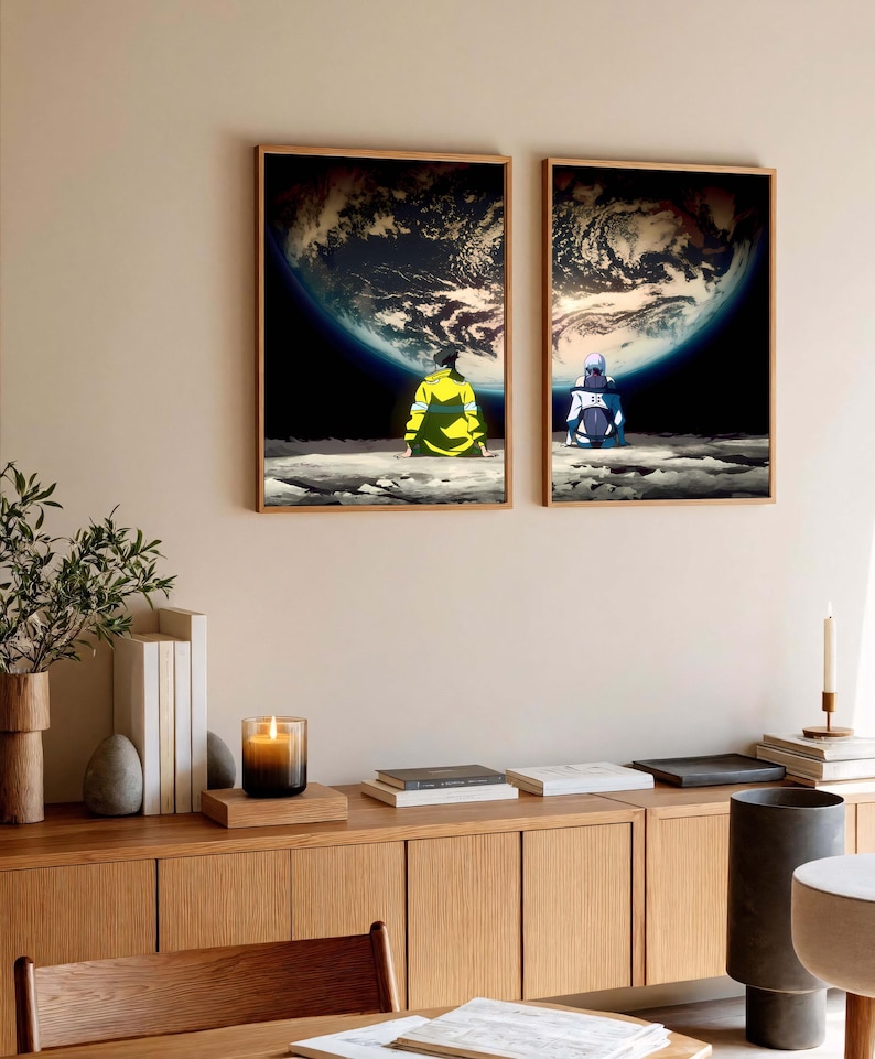 May include: Two framed art prints depict figures seated on a lunar surface, gazing at Earth. One figure wears yellow, the other blue. The artwork features a detailed depiction of the Earth against a dark, starry background.