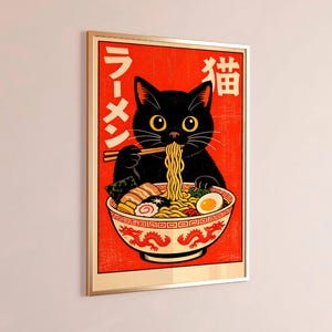 Puede incluir: Impresi&oacute;n art&iacute;stica enmarcada que muestra un gato negro comiendo ramen. El gato usa palillos para comer fideos de un cuenco decorativo. Fondo rojo con texto japon&eacute;s, en un marco dorado.