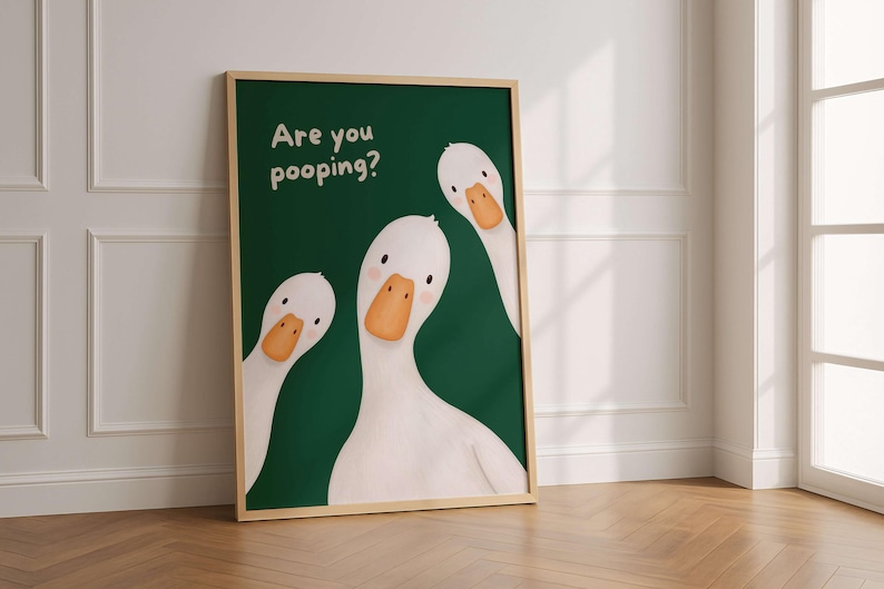 May include: A framed wall art print featuring three white geese with orange beaks against a dark green background. The text "Are you pooping?" is printed in white in the upper left corner. The geese have simple black eyes and pink cheeks.