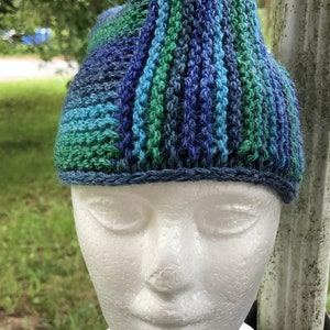 May include: A blue and green striped crocheted hat with a blue crocheted brim.