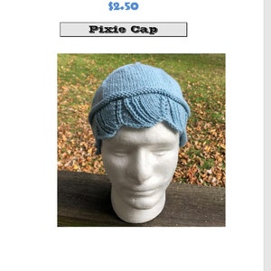 May include: A light blue knitted pixie cap with a scalloped edge. The cap is on a white mannequin head.