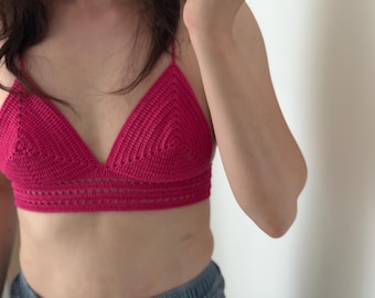 Puede incluir: Top de ganchillo de color magenta con escote triangular y tirantes finos. El top presenta un diseño detallado de tejido abierto en el borde inferior. La prenda hecha a mano es una prenda elegante.