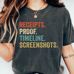 Könnte beinhalten: Ein dunkelgraues T-Shirt mit einer Grafik im Vintage-Stil, auf dem "RECEIPTS. PROOF. TIMELINE. SCREENSHOTS." steht.