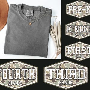 Peut inclure: Un t-shirt gris anthracite à col rond avec une étiquette indiquant la taille S, accompagné de cinq écussons hexagonaux à motif camouflage avec du texte blanc en lettres capitales : PRE-K, KINDER GARTEN, FIRST GRADE, THIRD GRADE, FOURTH GRADE.