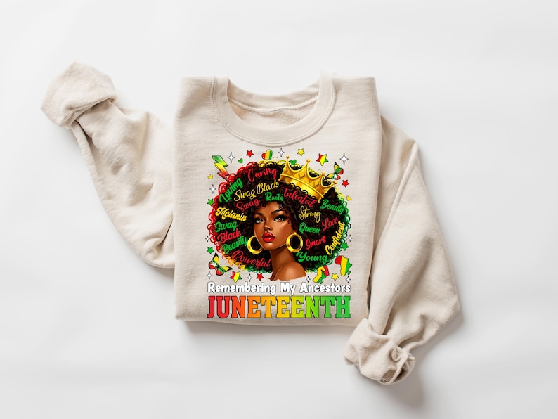 Puede incluir: Una sudadera crema con un gr&aacute;fico de una mujer negra con corona y pendientes dorados, con un afro colorido. El dise&ntilde;o incluye las palabras "Loving, Caring, Swag, Black, Beauty, Powerful, Strong, Queen, Confident, Young" y el texto "Remembering My Ancestors JUNETEENTH."